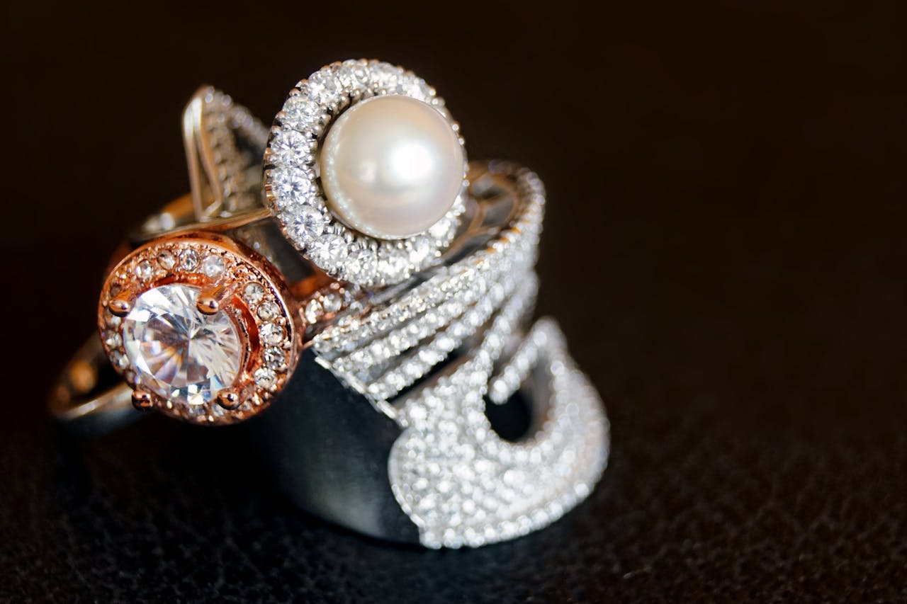 Mastering the First Impression: Your intriguing post title goes here Close-up of luxurious pearl and diamond rings with gold accents on a black background.